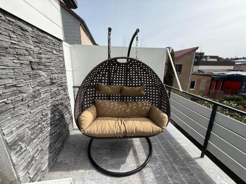 a swing chair sitting on a balcony at 80qm Luxus Apartment mit großer Terrasse in Saarbrücken