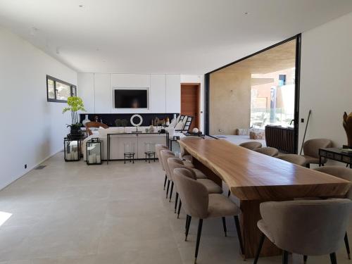 une cuisine et une salle à manger avec une table et des chaises en bois dans l'établissement Luxury and Relaxation - Villa Tevalba, à Calvi