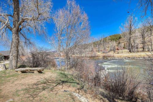 a park bench sitting next to a river with trees at 10 Cobblestone Ln in Pagosa Springs