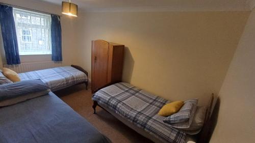 a bedroom with two twin beds and a window at Large countryside home in Tow Law