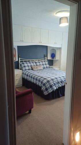 a bedroom with a bed with a blue and white blanket at Large countryside home in Tow Law