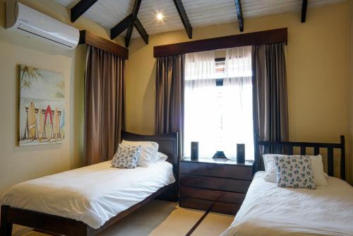 a bedroom with two twin beds and a window at Casa Marbella in Santa Teresa Beach