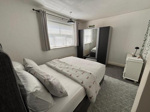 a small bedroom with a bed and a window at Spacious comfy flat near Airport and Altrincham in Wythenshawe
