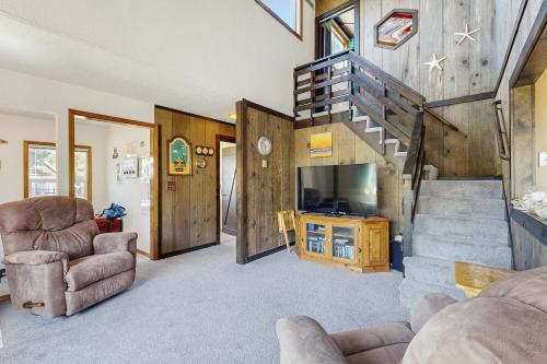 a living room with a staircase and a television at Rockaway Beach Surfer's Paradise in Rockaway Beach