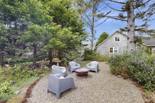 a group of chairs and a table in a yard at Cozy Coast Modern in Nedonna Beach