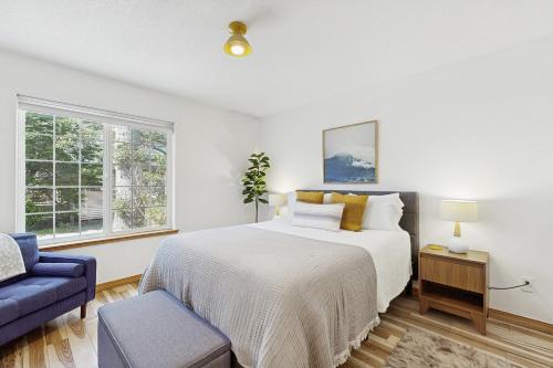 1 dormitorio blanco con 1 cama y 1 sofá azul en Cozy Coast Modern, en Nedonna Beach
