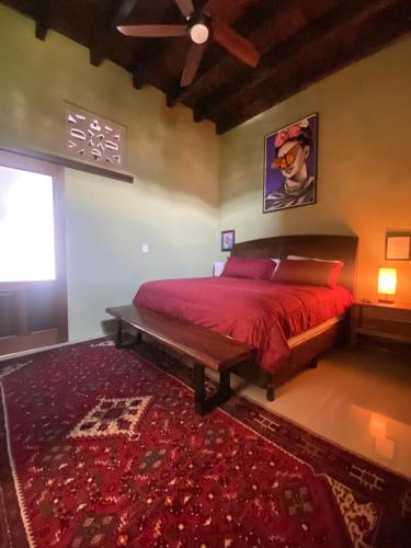 a bedroom with a bed with a red comforter at Castillo De La Santa Cruz in Guanajuato