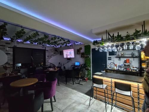 a restaurant with a bar and some tables and chairs at Agava Club in Sremska Kamenica