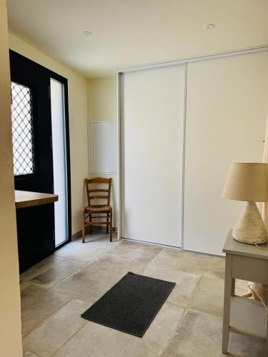 une pièce avec des portes coulissantes blanches et une chaise dans l'établissement Maison de charme - Jardin - Parking - Proche CEA Cadarache - ITER, à Saint-Paul-lès-Durance