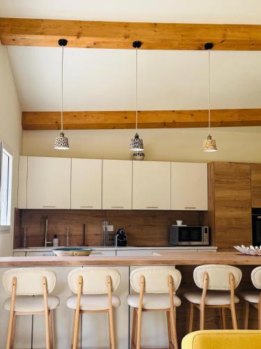 une cuisine avec des armoires blanches et une table avec des chaises dans l'établissement Maison de charme - Jardin - Parking - Proche CEA Cadarache - ITER, à Saint-Paul-lès-Durance