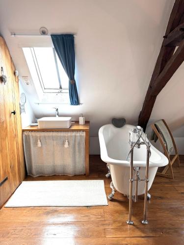 une salle de bain avec une baignoire et un lavabo dans l'établissement La Grange de Montrésor, à Montrésor