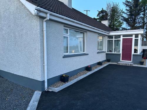 a house with a red door and a driveway at Carlingford View in Kilkeel