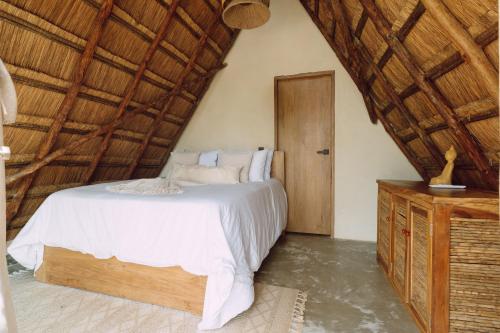 a bedroom with a bed and a wooden ceiling at VelaNova Paradise - HotelRetreat in Isla Fuerte