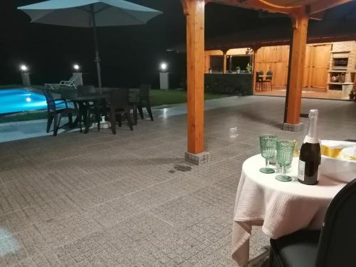 a table with a bottle of wine and glasses next to a pool at Eucalyptus Pink House in Covelo