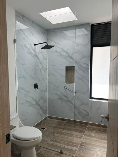 a bathroom with a glass shower with a toilet at Arrayanes 33, Ricaurte San Marcos in Ricaurte