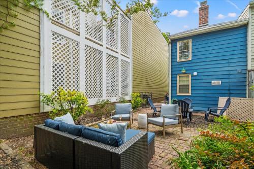 eine Terrasse mit einem Sofa und Stühlen neben einem blauen Haus in der Unterkunft The George in Alexandria