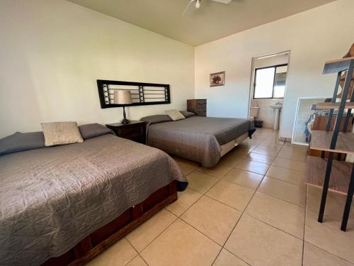 a hotel room with two beds and a window at Casa Llena de Vida LB8 Alberca privada VISTA A LA BAHIA in San Carlos