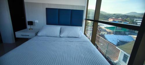 a bed in a room with a large window at Apartamento en el centro de Matagalpa in Matagalpa