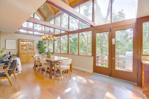 a dining room with a table and chairs and windows at Walk to Lake Arrowhead Village Gem with Lake Access in Lake Arrowhead