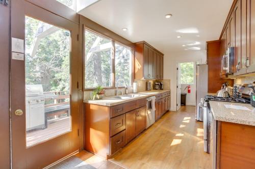a kitchen with wooden cabinets and a large window at Walk to Lake Arrowhead Village Gem with Lake Access in Lake Arrowhead