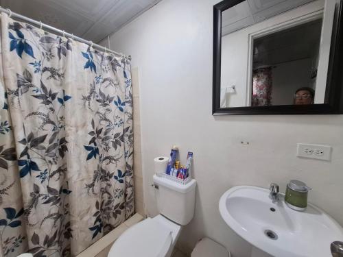 a bathroom with a toilet and a sink and a mirror at Casa Lilia Airport in Panama City