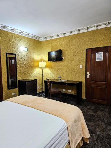 a hotel room with a bed and a desk in it at Antigua Inn Hotel in Guatemala