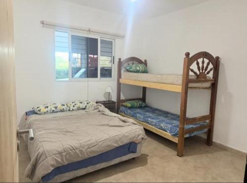 Un dormitorio con una cama y una litera y una ventana. en Los Abitos, en El Rodeo