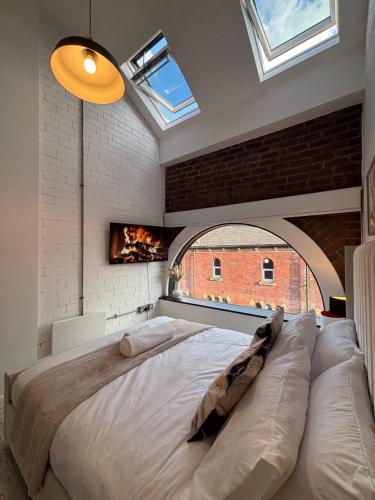 a bedroom with a large bed and a brick wall at Lux Stays - Luxury Apartment in Leeds City Centre near Canal in Leeds