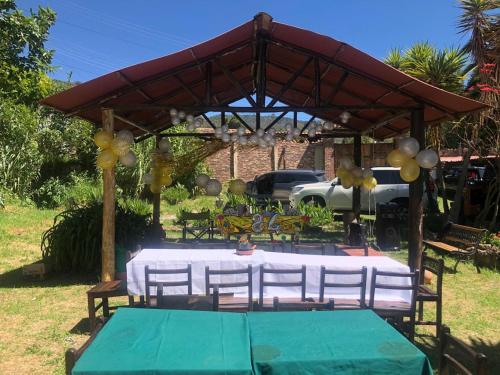 a table and chairs under a pavilion with a green table at Hostal Santa Isabel in Iza