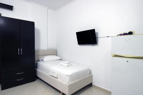 a bedroom with a bed and a tv on the wall at Vila Reni Risi in Ksamil