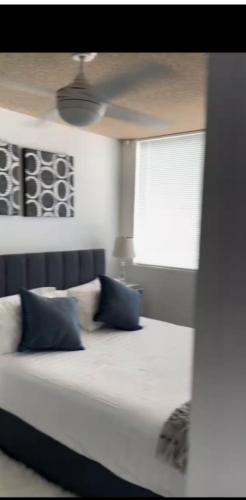a bed with two blue pillows in a room at Chic Retreat in Granville - steps to train ! in Clyde