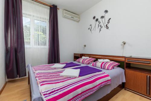 a bedroom with a bed with a striped blanket at Apartments and rooms with parking space Podgora, Makarska - 23916 in Podgora