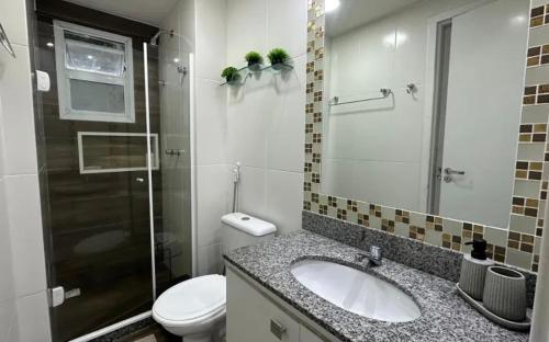 ein Badezimmer mit Waschbecken, Toilette und Dusche in der Unterkunft Porto Real Resort Suites apt Califórnia in Mangaratiba