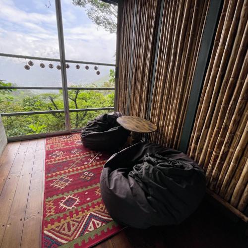 a room with two bean bags and a table at ANCESTRAL GLAMPING in Barbosa