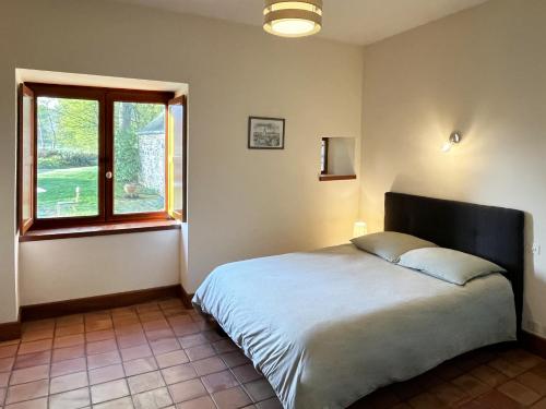 sypialnia z dużym łóżkiem i oknem w obiekcie La grande maison dans la prairie w mieście Bonnemain