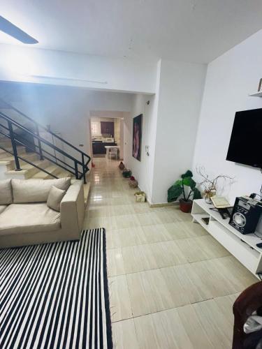 a living room with a couch and a flat screen tv at Marseilia beach2 فيلا النرجس in Dawwār Abū Maḩrūs