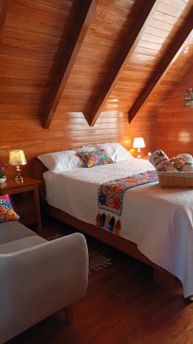 a bedroom with two beds and a chair at La Cabaña de Mary in Oxapampa