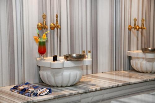 a room with two sinks and a vase on a table at Tilya Resort Hotel in Trabzon