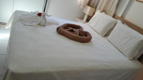 a bed with a brown ring on top of it at Apartamento no Iloa Residence - Com Enxoval Completo in Barra de São Miguel