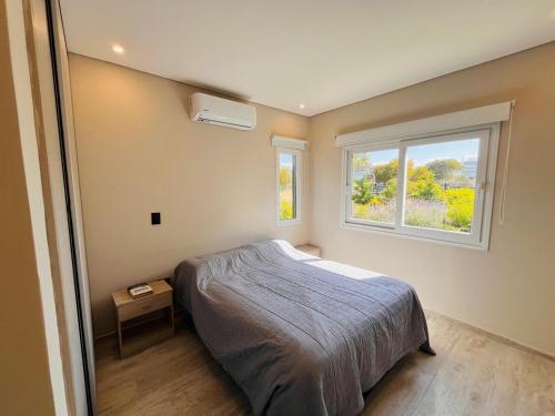 une chambre avec un lit et une fenêtre dans l'établissement Costa Esmeralda 4 Dorm,4 Baños,10 perso, pileta, à Costa Esmeralda