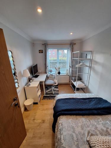 a bedroom with a bed and a desk with a computer at Cosy Gated Room with Free Secure Parking Private Bathroom in Woking