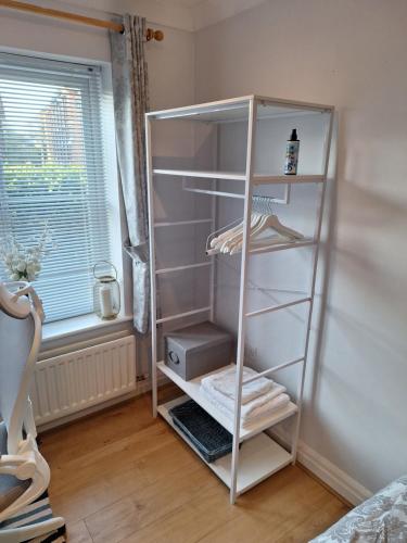 a white book shelf in a room with a window at Cosy Gated Room with Free Secure Parking Private Bathroom in Woking