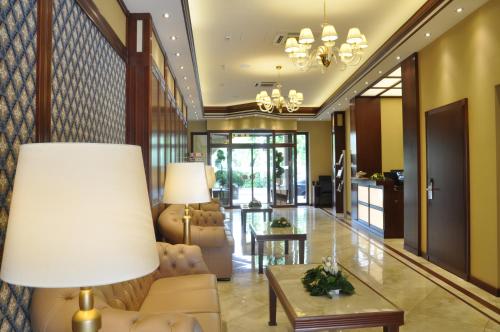 a lobby with a couch and a table and a lamp at Centrum Hotel in Debrecen