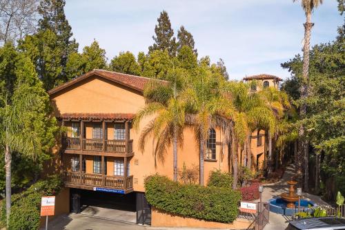 a large house with palm trees in front of it at Hotel Zico, BW Signature Collection in Mountain View