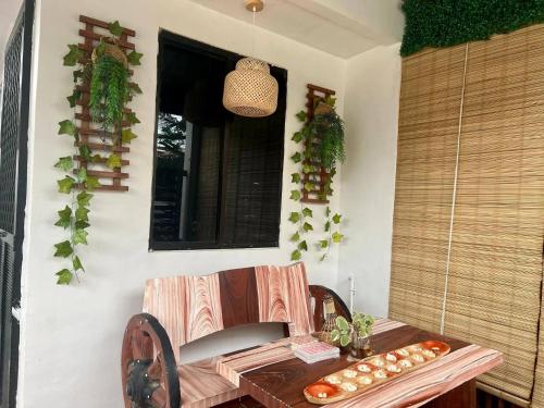 a table and chair on a patio with a window at Cozy Holiday Home in San Pablo City for Groups of 8-10 in Tiaong