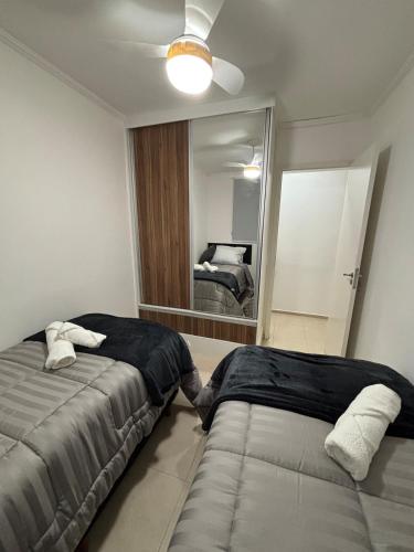 a bedroom with two beds and a large mirror at Seminate Apartamento in Franca