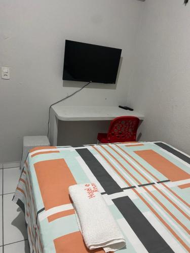 a bedroom with a bed with a desk and a television at Hotel e Pousada REQUINTTE in Parnaíba