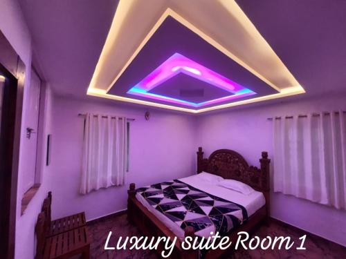 a bedroom with a bed with a purple ceiling at KODAI RiYA PARADISE in Kodaikānāl