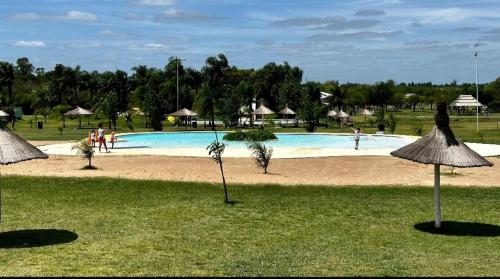 Una gran piscina con gente en un parque. en Casa en complejo termal, en María Grande
