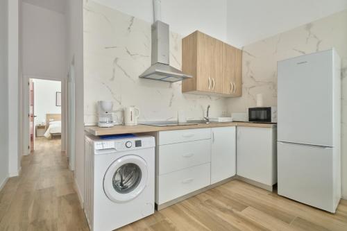 a white kitchen with a washer and dryer in it at Hasta para 6 viajeros, Luz Natural Cocina Equipada in Algeciras